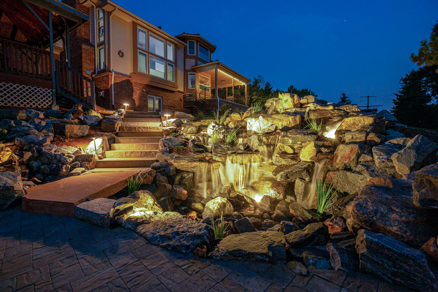 photo of a large natural rock water feature at night with lighting
