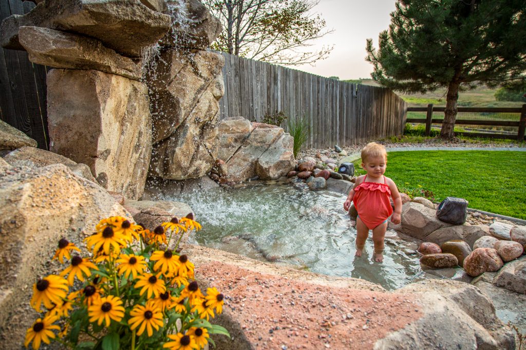 little girl playing in a water feature