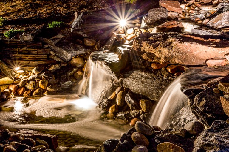 photo of a large natural rock water feature with starburst light